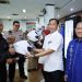 Komisaris Jasa Raharja M. Khoerur Roziqin menyerahkan helm kepada wajib pajak tertib sebagai simbol kampanye keselamatan berkendara saat kunjungan kerja di Samsat Kota Semarang III, Senin (29/9/2025). (Dok. Humas JR)