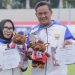 Pasangan atlet gateball Provinsi Jambi, Ade Candra dan Belinda, memperlihatkan medali perak dan piagam penghargaan yang mereka raih pada ajang Pornas Korpri XVII di Sumatera Selatan. (Dok. Tim Gateball Jambi)