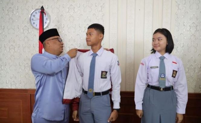 Wakil Gubernur Kepulauan Riau Nyanyang Haris Pratamura mengenakan jaket resmi Paskibraka Provinsi Kepri kepada Bagas Yudha Pratama, calon Pasukan Pengibar Bendera Pusaka (Paskibraka) Tingkat Nasional tahun 2025 asal Kabupaten Karimun, di Kantor Gubernur Kepri, Pulau Dompak, Tanjungpinang, Jumat (11/7/2025). (Dok. Ikram)