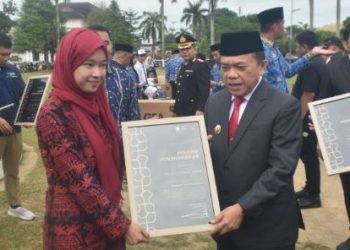 Gubernur Jambi Al Haris menyerahkan piagam penghargaan kepada salah satu pemuda berprestasi dalam upacara peringatan Hari Sumpah Pemuda ke-97 di Lapangan Kantor Gubernur Jambi, Senin (28/10/2025).