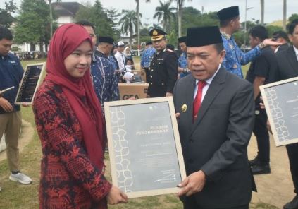 Gubernur Jambi Al Haris menyerahkan piagam penghargaan kepada salah satu pemuda berprestasi dalam upacara peringatan Hari Sumpah Pemuda ke-97 di Lapangan Kantor Gubernur Jambi, Senin (28/10/2025).