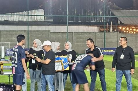 Plt Kadinkes Provinsi Jambi Syafri Mail menyerahkan hadiah dan piala bergilir kepada tim Dinkes Muaro Jambi usai memenangkan final Turnamen Mini Soccer HKN ke-61 di Lapangan Sepadan Lane, Kota Jambi, Selasa (28/10/2025) malam. (Dok, Daus)