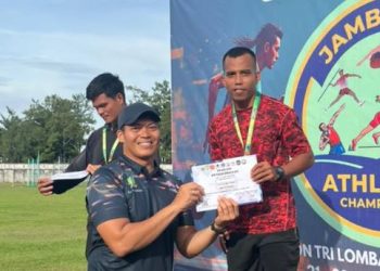 Ade Mardian Syahputra (kanan) menerima piagam penghargaan usai menjuarai nomor lari 100 meter dan 200 meter dalam Jambi Open Athletics Championship 2025 di Stadion Tri Lomba Juang KONI Jambi, Jumat (21/11/2025). (Dok. Daus)