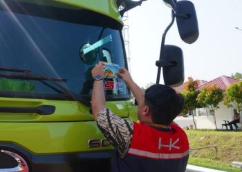 Petugas Hutama Karya menempelkan stiker imbauan keselamatan “Zero ODOL” di kaca depan kendaraan angkutan barang dalam kegiatan sosialisasi di salah satu ruas tol. (Dok. HK)