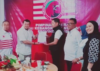 Ketua Pimda PKN Provinsi Jambi Mirzal Muarrohma, SH, menyerahkan Surat Keputusan (SK) kepengurusan kepada Muhammad Amin sebagai Ketua DPC PKN Kota Jambi, Selasa (13/12/2025) (Dok. Nahar)