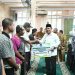 Gubernur Kepri  Ansar Ahmad menyalami masyarakat saat penyerahan bantuan hibah dan program perlindungan BPJS Ketenagakerjaan bagi nelayan dan petani di Masjid Darul Muttaqin, Taman Cipta Asri II, Selasa (9/12/2025). (Dok. Tri)