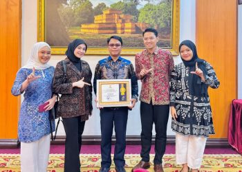 Direktur Utama Perumdam Tirta Mayang Kota Jambi, Dwike Riantara (tengah) menerima penghargaan Anugerah Keterbukaan Informasi Publik Tahun 2025 kategori BUMD di Rumah Dinas Gubernur Jambi, Rabu (17/12/2025). (Dok. Daus)