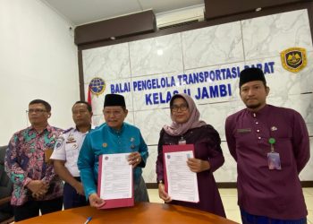 Kepala BPTD Kelas II Jambi Benny Nurdin Yusuf (kiri) dan Kepala Dinas Sosial Kota Jambi Yunita Indrawati menunjukkan dokumen Nota Kesepahaman usai penandatanganan kerja sama penanganan orang terlantar dan ODGJ di Terminal Tipe A Alam Barajo, Kota Jambi, Senin (6/1/2026). (Dok. Daus)