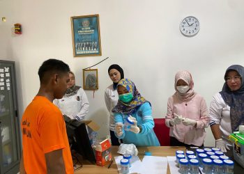 Petugas BNNK Batanghari melakukan pemeriksaan sampel urine pegawai dan anak binaan saat pelaksanaan tes urine di LPKA Kelas II Muara Bulian, Jumat (9/1/2026). (Dok. Humas)