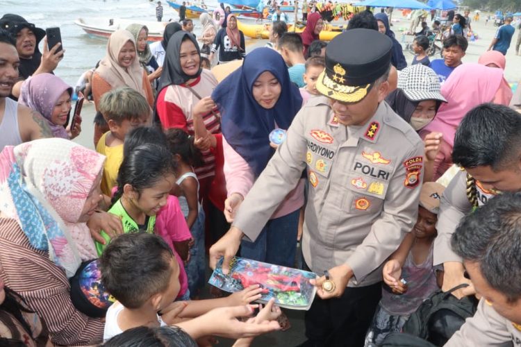 Kapolda Bengkulu Irjen Pol. Mardiyono menyapa dan membagikan mainan kepada anak-anak saat meninjau aktivitas wisata di Pantai Zakat, Kota Bengkulu, Jumat (27/3/2026) (Dok. Yola)