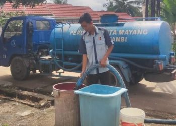 Petugas Perumdam Tirta Mayang menyalurkan air bersih menggunakan mobil tangki kepada warga terdampak gangguan distribusi akibat perbaikan Instalasi Pengolahan Air (IPA) Broni 1 di Kota Jambi. (Dok.,Erit)