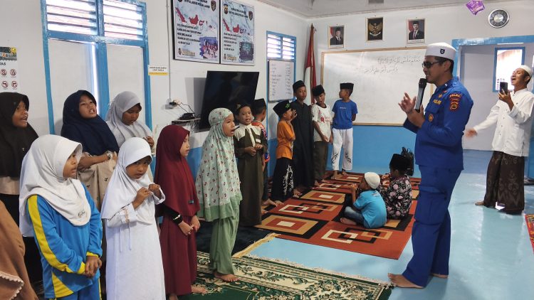Personel Ditpolairud Polda Jambi memberikan pembinaan keagamaan kepada anak-anak di Rumah Baca Bhayangkara Bahari, Kampung Pulau Pandan, Kota Jambi, Kamis (30/4/2026). (Dok. Humas)
