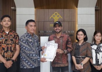 Mahasiswa internasional Universitas Jambi asal Pakistan, Ahmed Jamshaid, menerima dokumen Apostille dari petugas Kantor Wilayah Kementerian Hukum Jambi untuk keperluan administrasi studi di Italia, Kamis (30/4/2026). (Dok. Stepanus)
