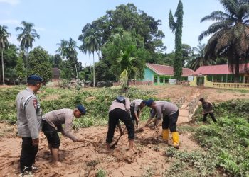 Personel Satbrimob Polda Jambi membersihkan material lumpur akibat banjir di Desa Teluk Kecimbung, Kecamatan Bathin VIII, Kabupaten Sarolangun. (Dok. Humas)