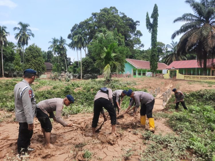 Personel Satbrimob Polda Jambi membersihkan material lumpur akibat banjir di Desa Teluk Kecimbung, Kecamatan Bathin VIII, Kabupaten Sarolangun. (Dok. Humas)