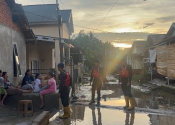 Personel Brimob Polda Jambi meninjau kondisi permukiman warga yang terdampak banjir di Desa Pematang Gajah, Kecamatan Jaluko, Kabupaten Muaro Jambi, Sabtu (2/5/2026) (Dok. Nahar)