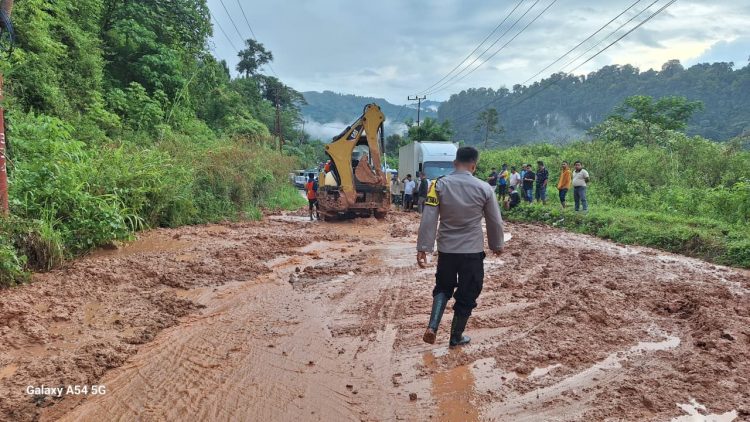 Petugas kepolisian bersama alat berat melakukan penanganan material longsor yang menutupi Jalan Lintas Kerinci–Bangko di Desa Muara Hemat, Kecamatan Batang Merangin, Kabupaten Kerinci, Jumat (8/5/2026). (Dok. Humas)
